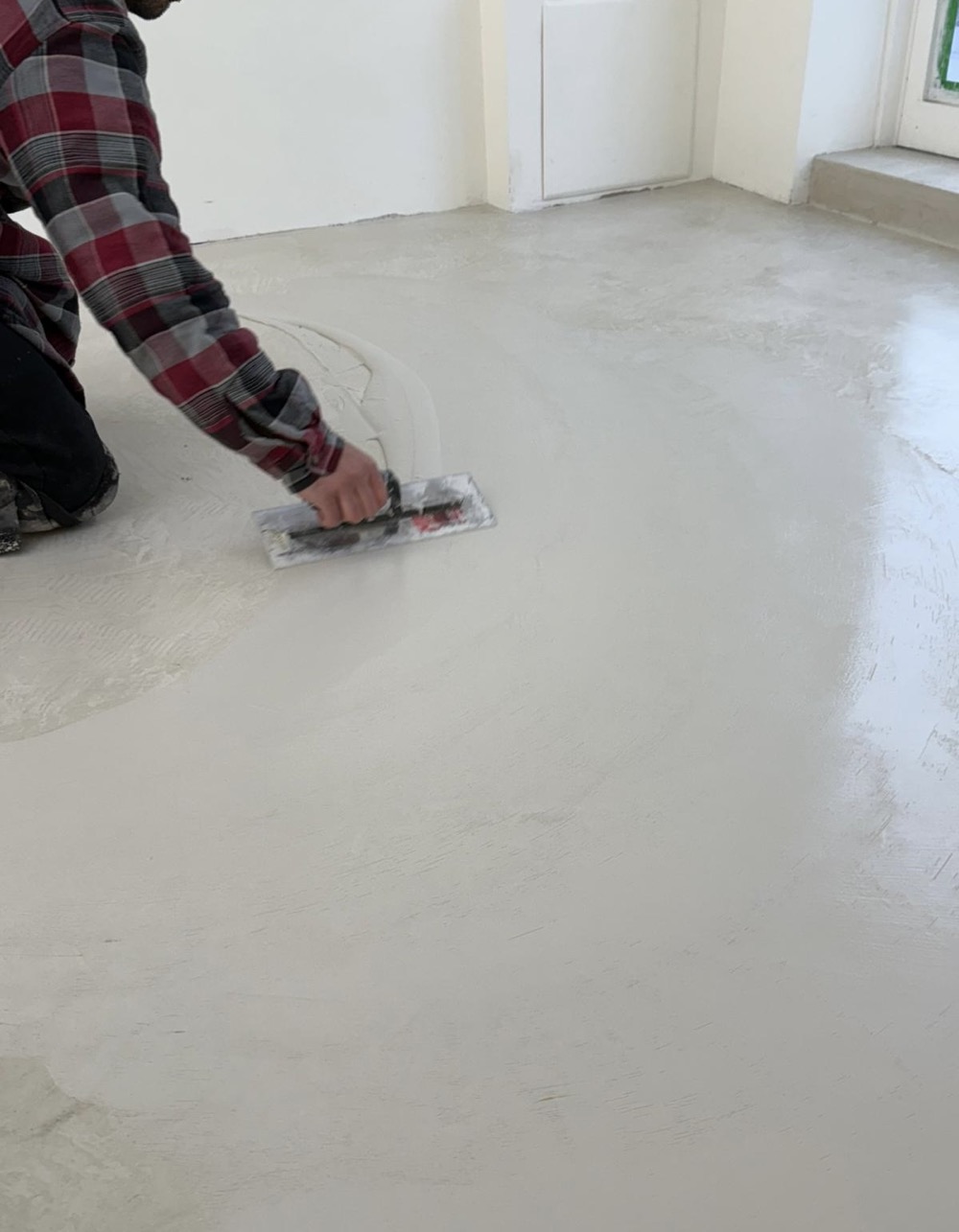 Craftsman applying microcement by hand — professional application process