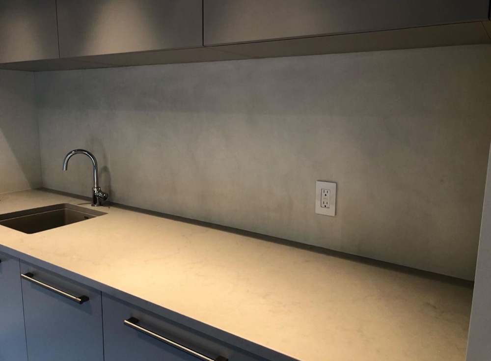 Seamless grey microcement kitchen backsplash and countertop in a Toronto-area kitchen